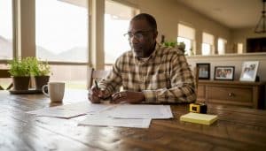 Buyer reviewing closing cost documents at kitchen table